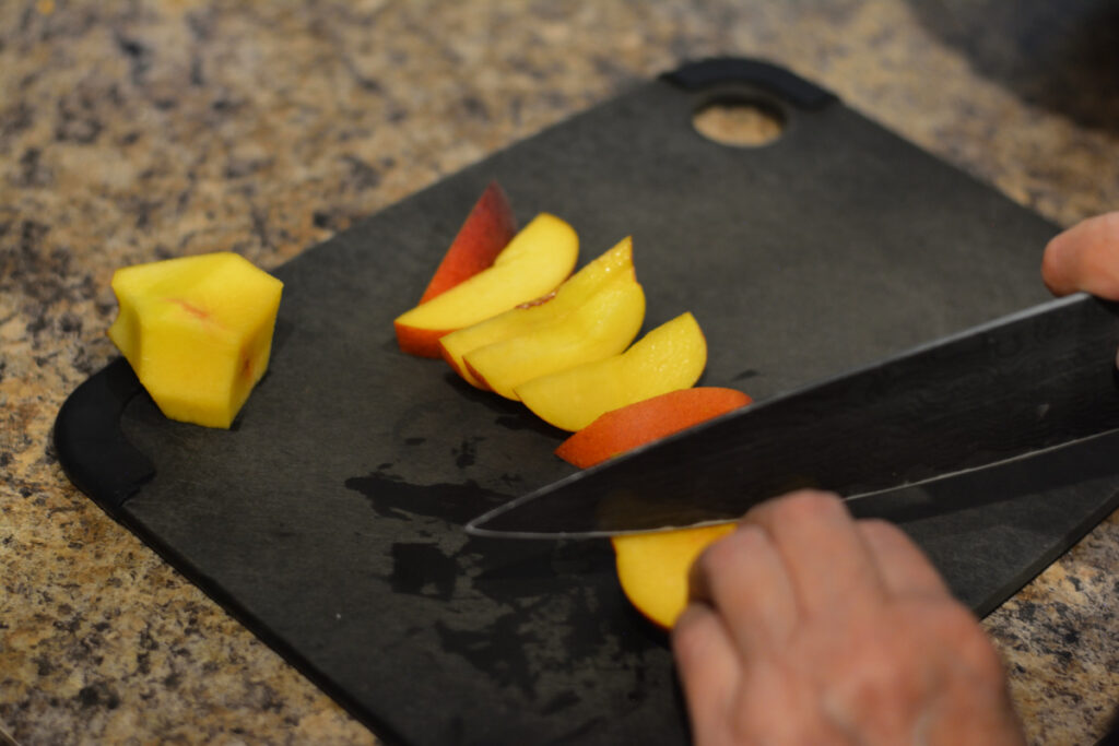 cutting peach on slate cutting board