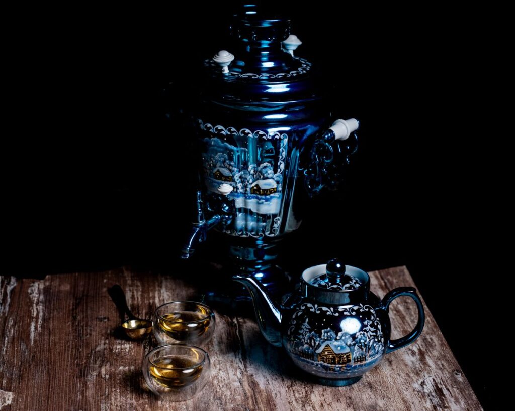 Blue samovar and teapot with winter scape on wooden table